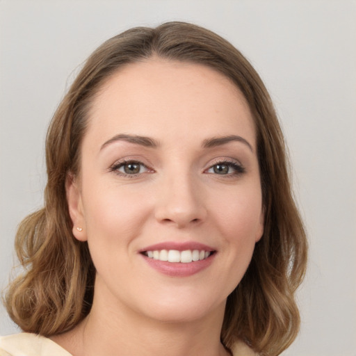 Joyful white young-adult female with medium  brown hair and green eyes