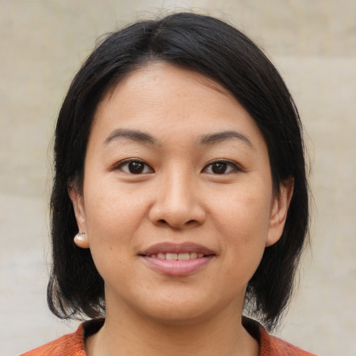 Joyful asian young-adult female with medium  brown hair and brown eyes