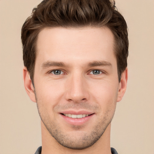 Joyful white young-adult male with short  brown hair and grey eyes