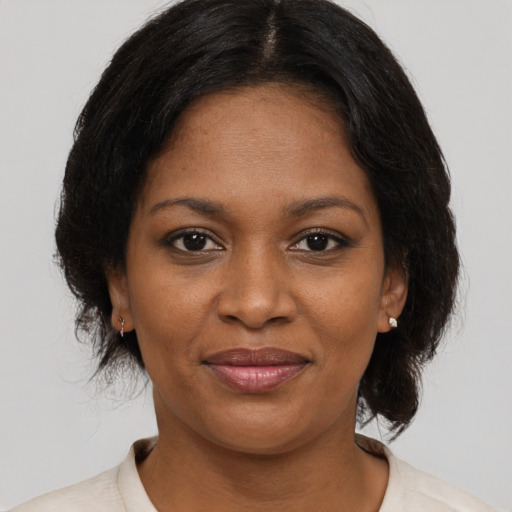 Joyful black adult female with medium  brown hair and brown eyes