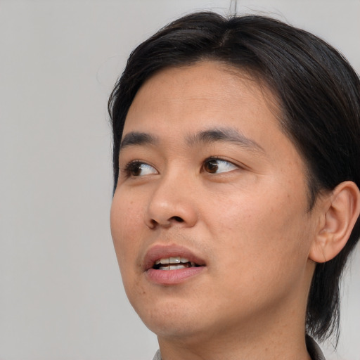 Joyful asian young-adult male with medium  black hair and brown eyes