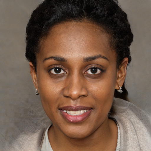 Joyful black young-adult female with short  brown hair and brown eyes