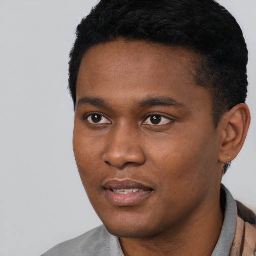 Joyful black young-adult male with short  black hair and brown eyes