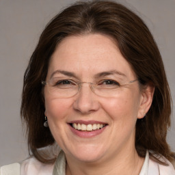 Joyful white adult female with medium  brown hair and grey eyes