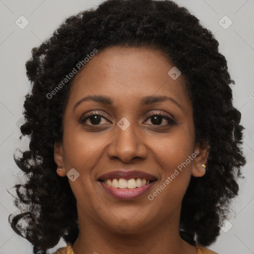 Joyful black young-adult female with long  brown hair and brown eyes