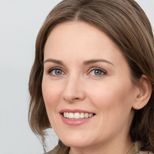 Joyful white young-adult female with medium  brown hair and grey eyes