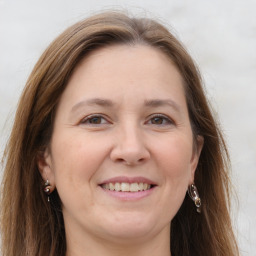 Joyful white adult female with long  brown hair and grey eyes