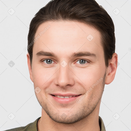 Joyful white young-adult male with short  brown hair and grey eyes