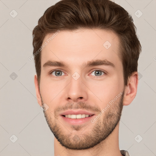 Joyful white young-adult male with short  brown hair and grey eyes