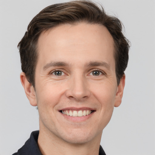 Joyful white adult male with short  brown hair and grey eyes