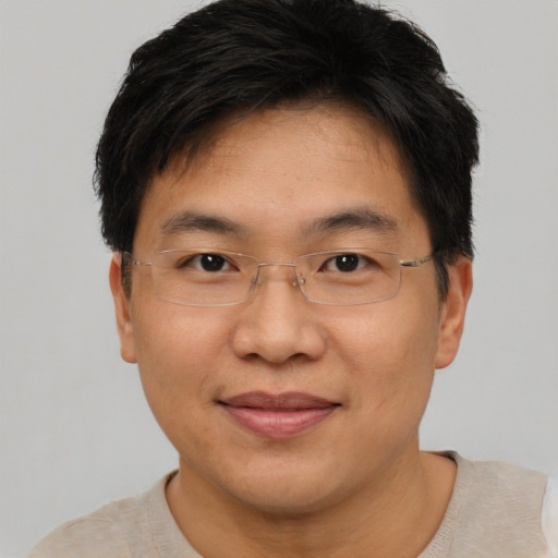 Joyful asian adult male with short  brown hair and brown eyes