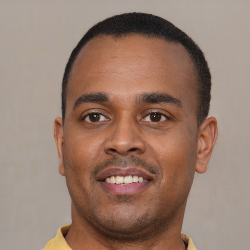 Joyful black young-adult male with short  black hair and brown eyes