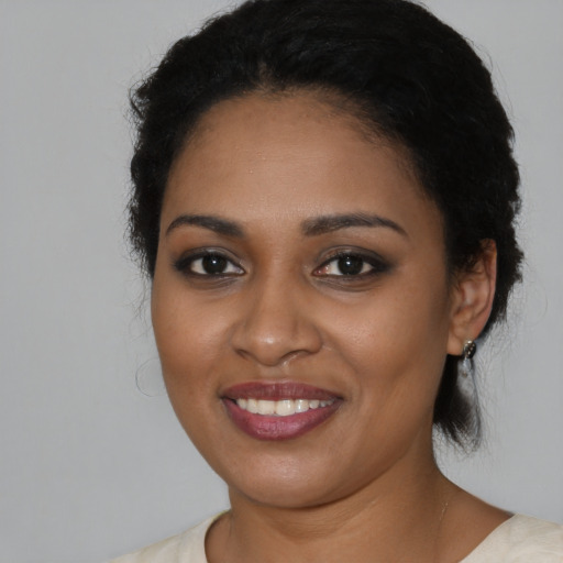 Joyful black young-adult female with medium  black hair and brown eyes