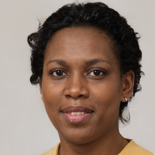 Joyful black adult female with short  brown hair and brown eyes
