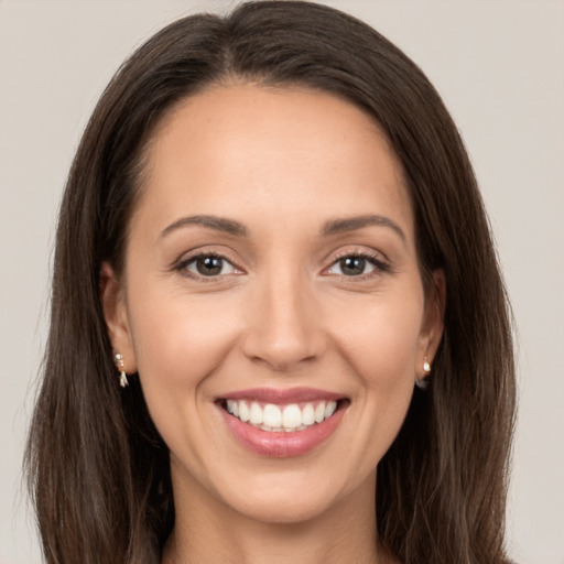 Joyful white young-adult female with long  brown hair and brown eyes