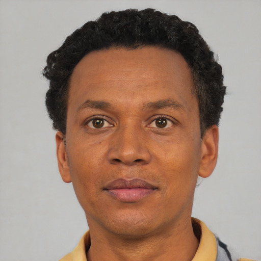 Joyful black adult male with short  brown hair and brown eyes
