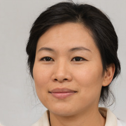 Joyful asian adult female with medium  brown hair and brown eyes