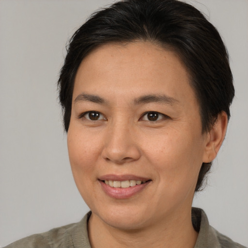 Joyful asian adult female with medium  brown hair and brown eyes