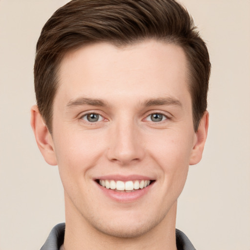 Joyful white young-adult male with short  brown hair and grey eyes