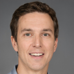 Joyful white adult male with short  brown hair and grey eyes