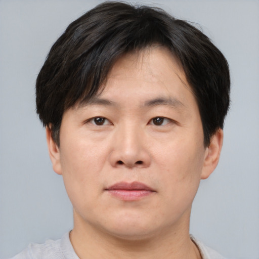 Joyful asian adult male with short  brown hair and brown eyes
