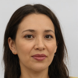 Joyful white adult female with long  brown hair and brown eyes