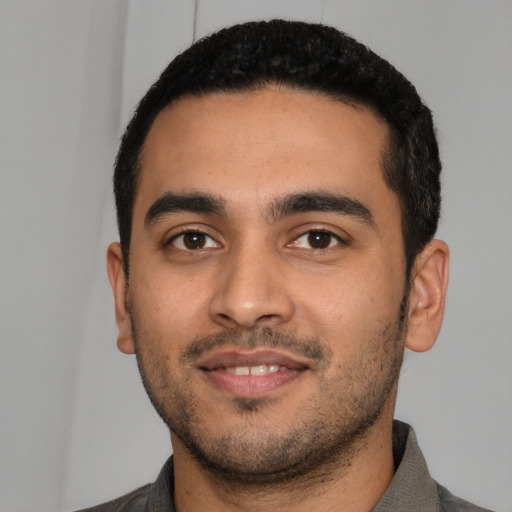 Joyful latino young-adult male with short  black hair and brown eyes