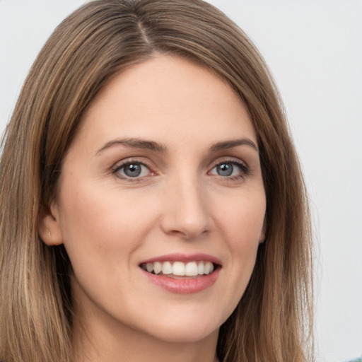 Joyful white young-adult female with long  brown hair and grey eyes