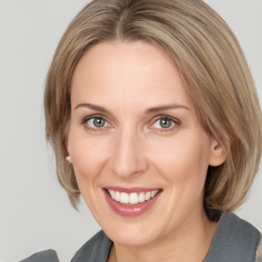 Joyful white adult female with medium  brown hair and grey eyes