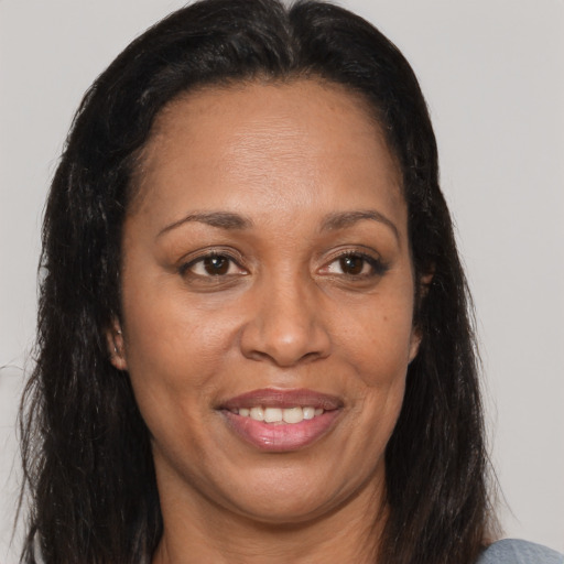 Joyful black adult female with long  brown hair and brown eyes