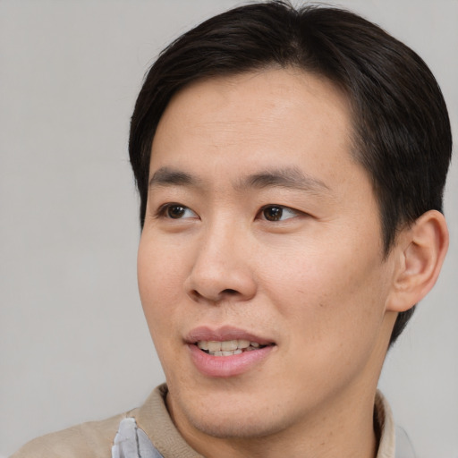 Joyful asian young-adult male with short  brown hair and brown eyes
