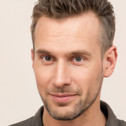 Joyful white adult male with short  brown hair and brown eyes