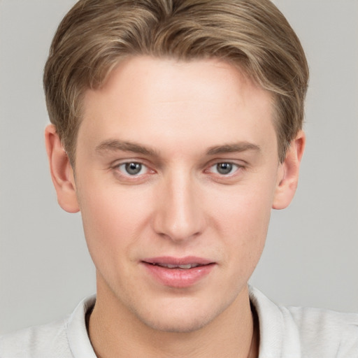 Joyful white young-adult male with short  brown hair and grey eyes