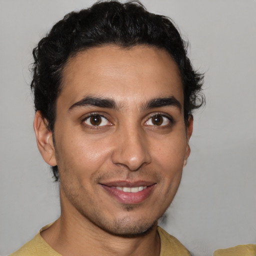 Joyful latino young-adult male with short  brown hair and brown eyes