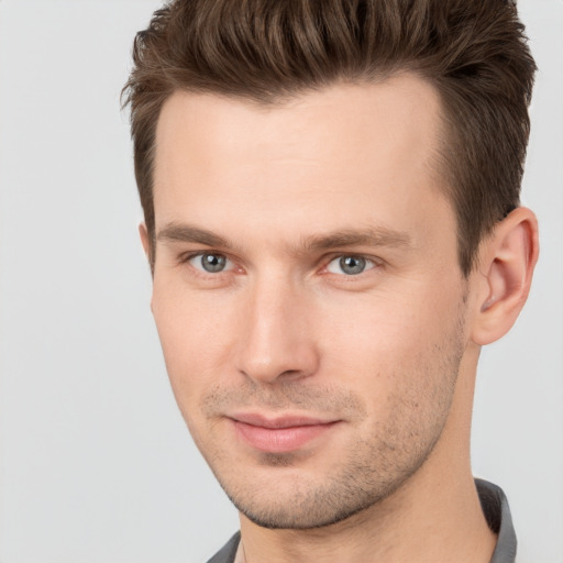 Joyful white young-adult male with short  brown hair and grey eyes