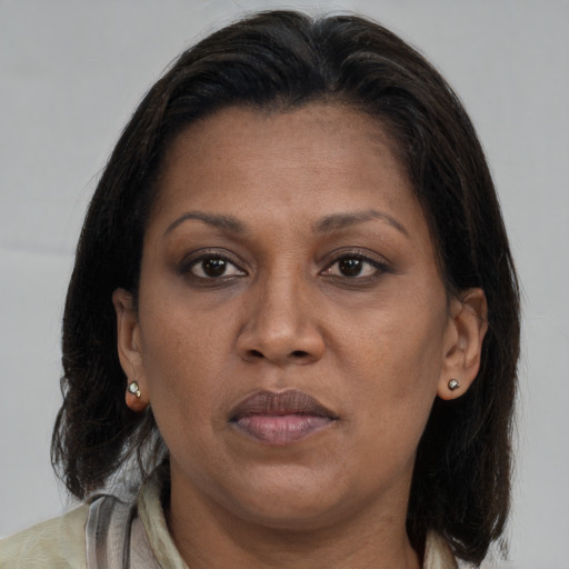 Joyful black adult female with medium  brown hair and brown eyes