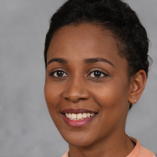 Joyful black young-adult female with short  brown hair and brown eyes