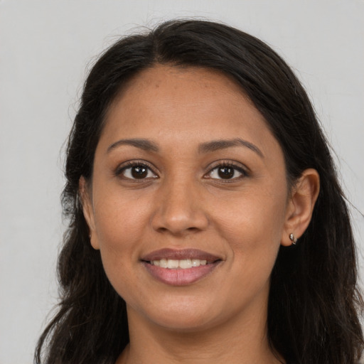 Joyful latino adult female with long  brown hair and brown eyes