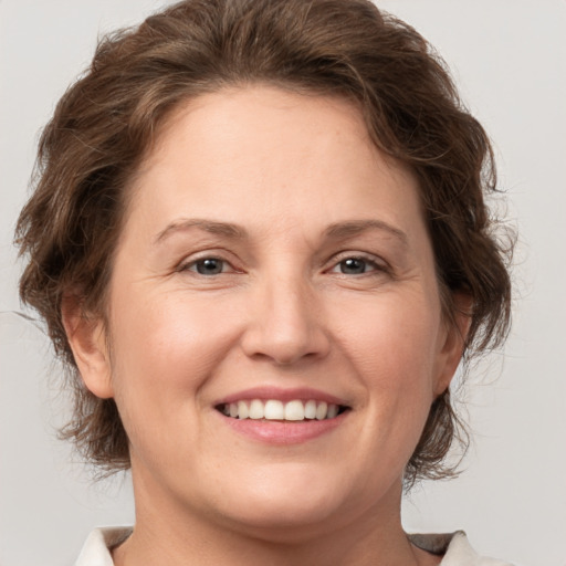 Joyful white young-adult female with medium  brown hair and green eyes