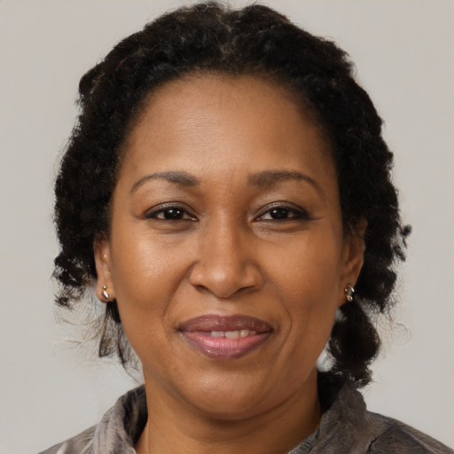 Joyful black adult female with medium  brown hair and brown eyes