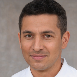 Joyful white adult male with short  black hair and brown eyes