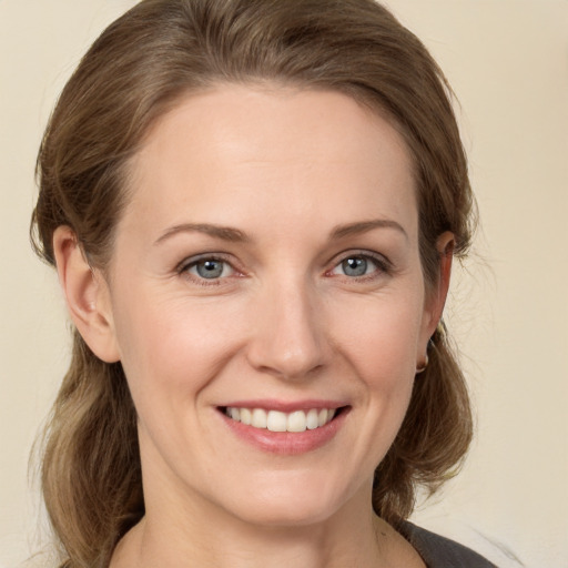 Joyful white young-adult female with medium  brown hair and grey eyes