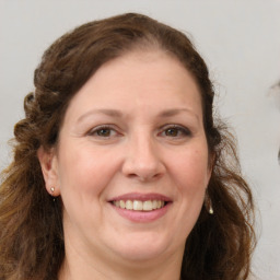 Joyful white adult female with long  brown hair and brown eyes