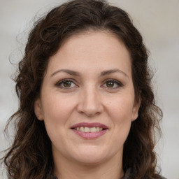 Joyful white adult female with long  brown hair and brown eyes