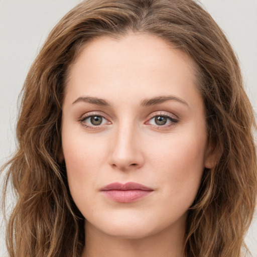 Joyful white young-adult female with long  brown hair and green eyes