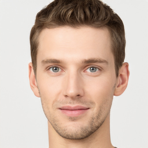 Joyful white young-adult male with short  brown hair and grey eyes