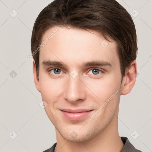 Joyful white young-adult male with short  brown hair and grey eyes