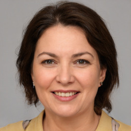 Joyful white adult female with medium  brown hair and brown eyes