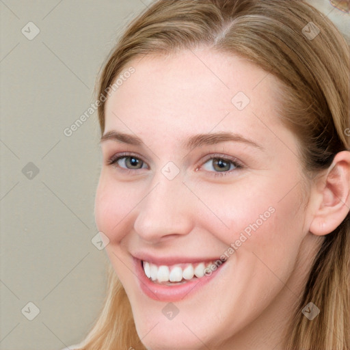 Joyful white young-adult female with long  brown hair and blue eyes