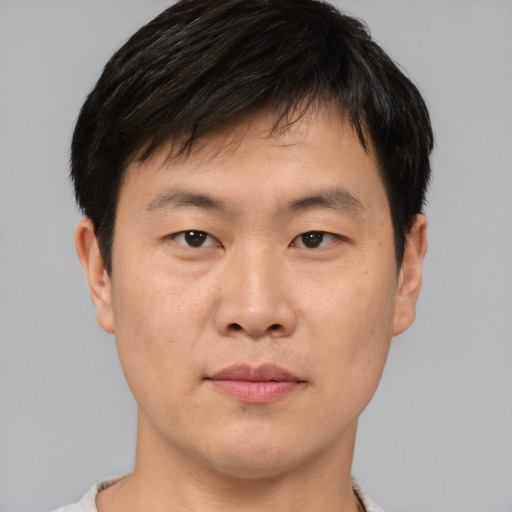 Joyful asian young-adult male with short  black hair and brown eyes